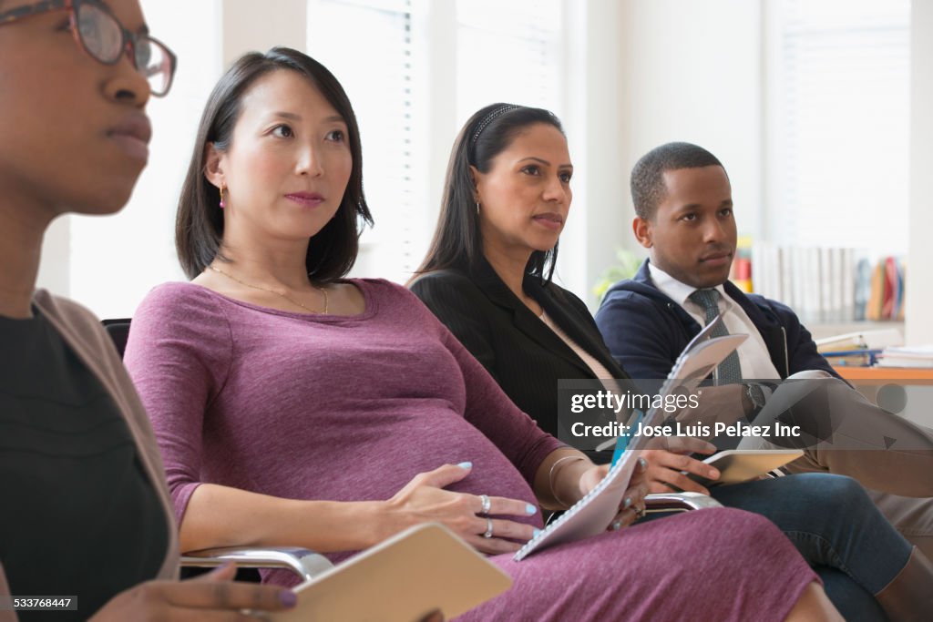 Business people listening in presentation in office