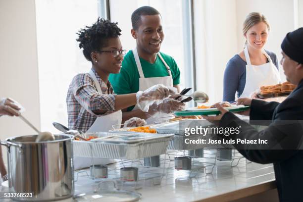 volunteers serving food in cafeteria - rubber 55 stock-fotos und bilder