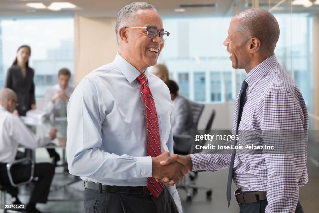 Businessmen shaking hands in office