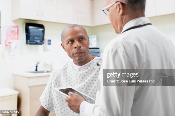 doctor comforting patient in office - hospital gown stock pictures, royalty-free photos & images
