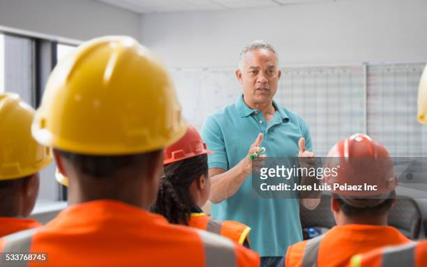 speaker giving presentation to construction workers - construction worker office people stock pictures, royalty-free photos & images
