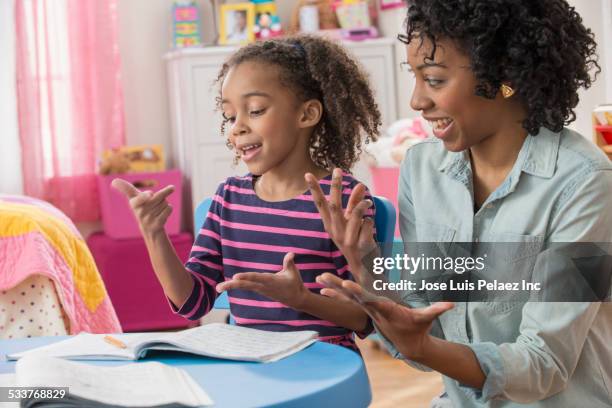 mother helping daughter do math homework in playroom - idiomas imagens e fotografias de stock