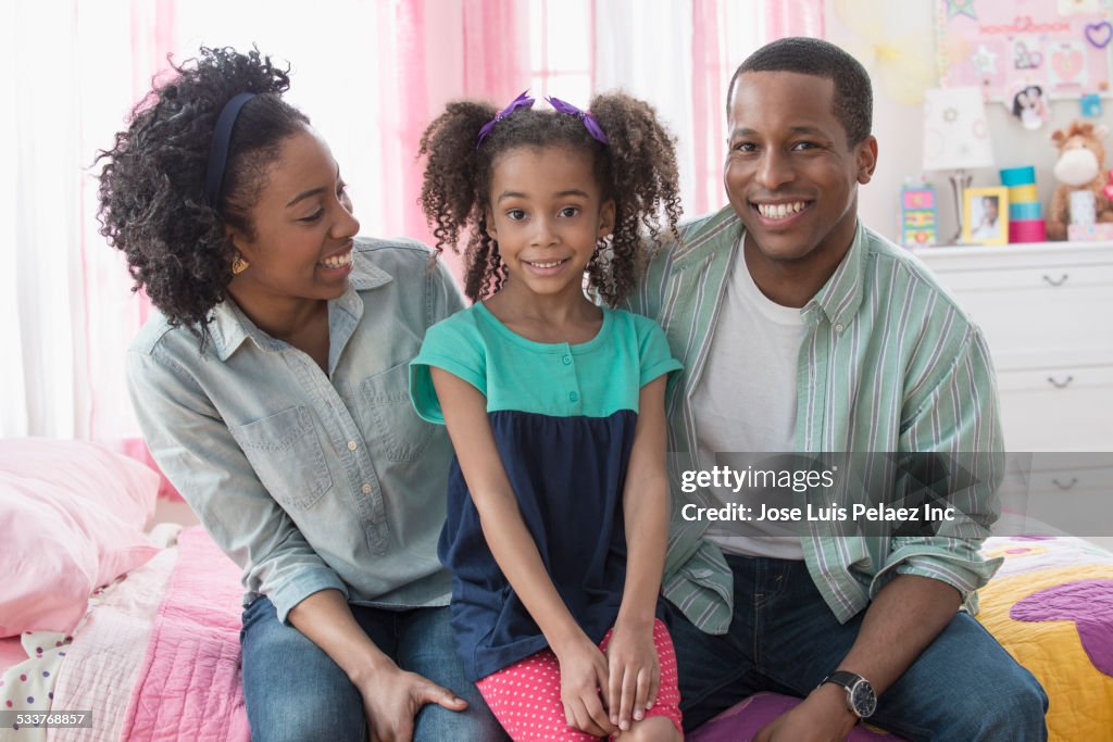 Family smiling together on bed