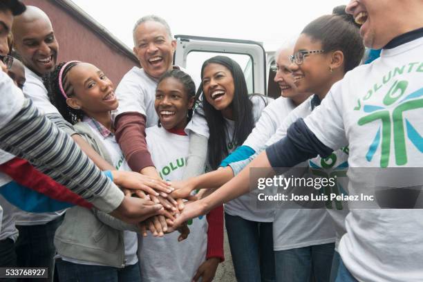 Volunteers stacking hands and cheering