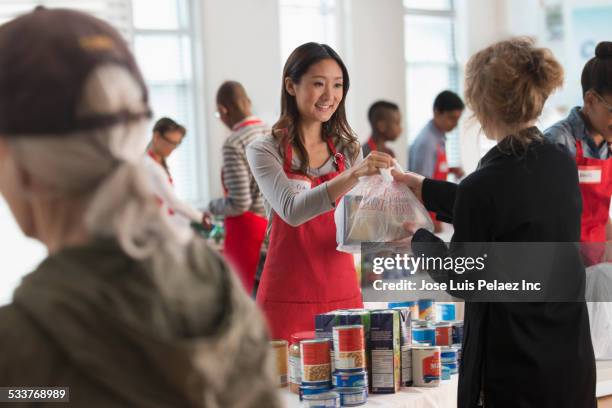 volunteers handing out food at food drive - volunteer stockfoto's en -beelden