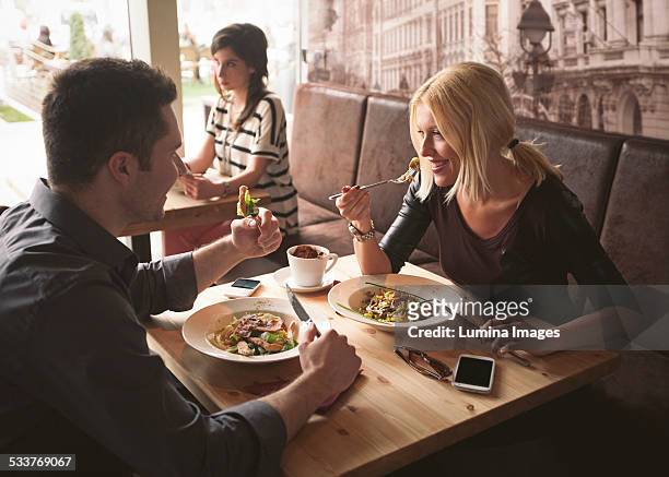 couple eating in cafe - mesa cafeteria perfil fotografías e imágenes de stock