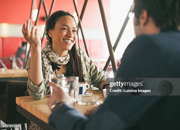 couple talking in cafe - coffee shop couple stock pictures, royalty-free photos & images