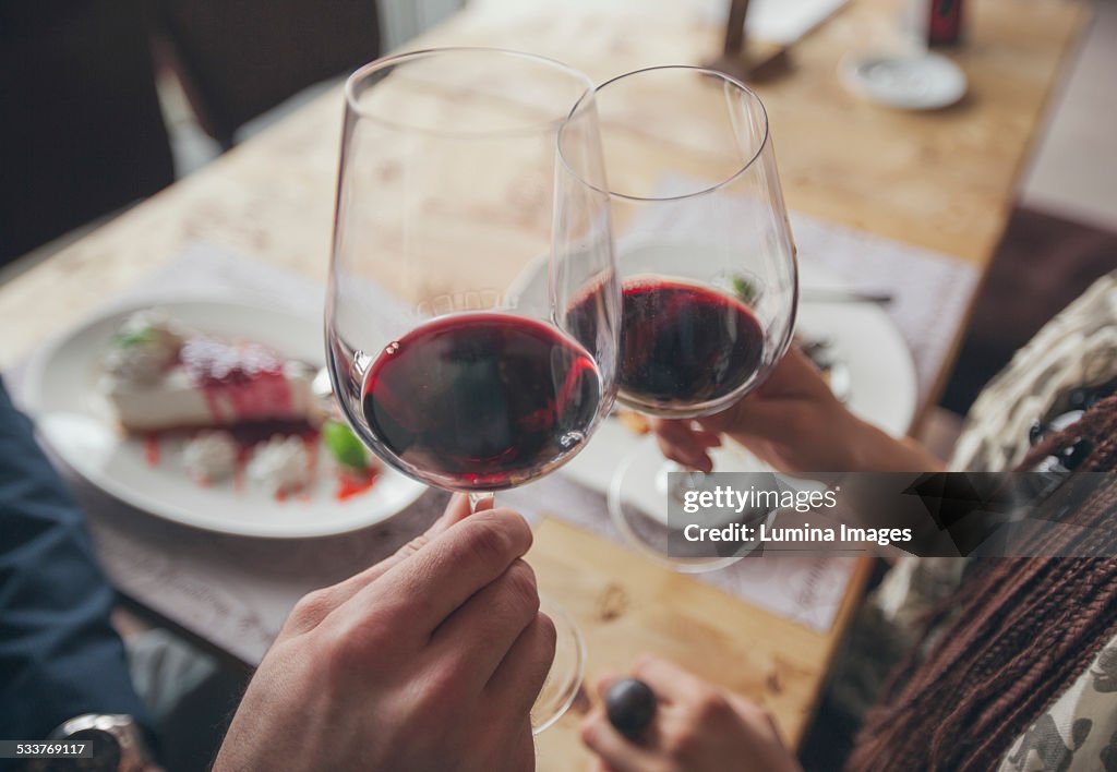 Couple toasting with wine in cafe