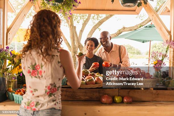 vendor showing produce to couple at farmers market - virginia beach 個照片及圖片檔