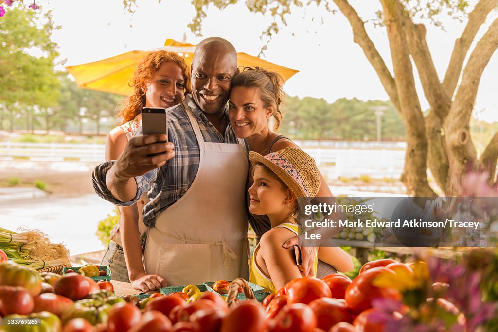 Family taking cell phone selfie at farmers market
