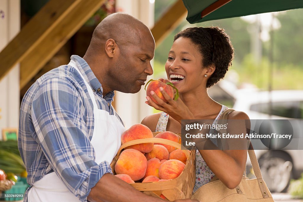 African American people smelling produce at farmers market