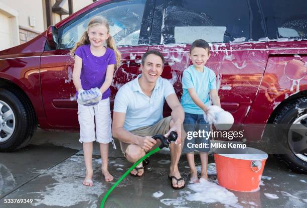caucasian father and children washing car in driveway - shoes sponge fotografías e imágenes de stock
