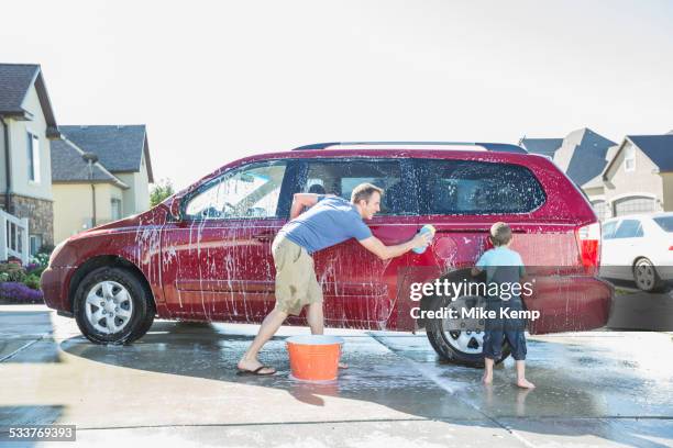 caucasian father and son washing car in driveway - utah house stock pictures, royalty-free photos & images