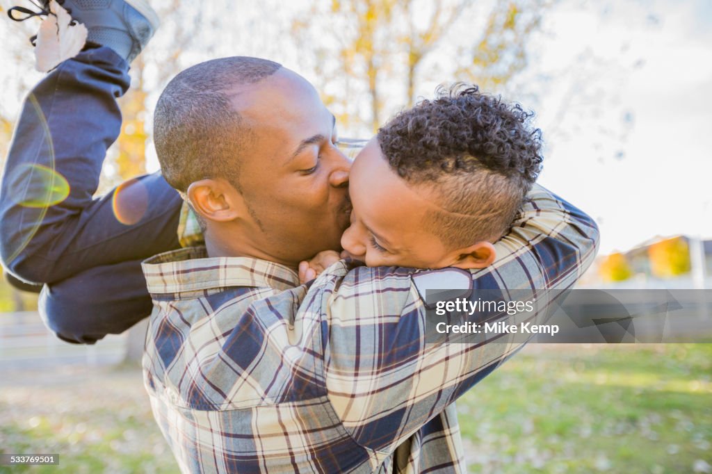 Father kissing son outdoors