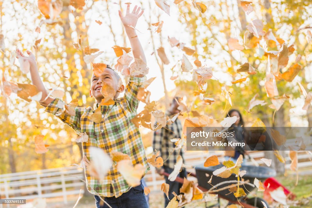 Boy playing in autumn leaves