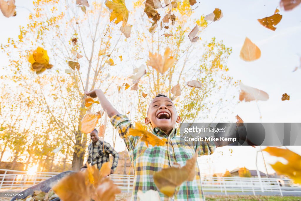 Boy playing in autumn leaves