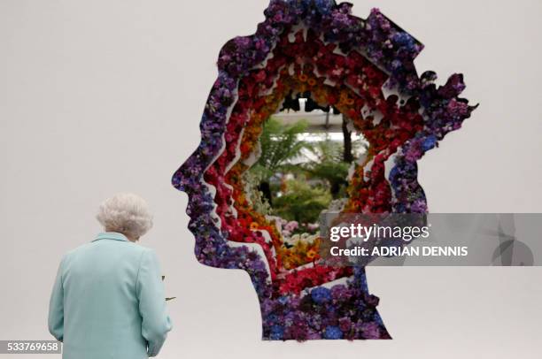 Britain's Queen Elizabeth II looks at a floral exhibit by the New Covent Garden Flower Market, which features an image of the Queen, during a visit...