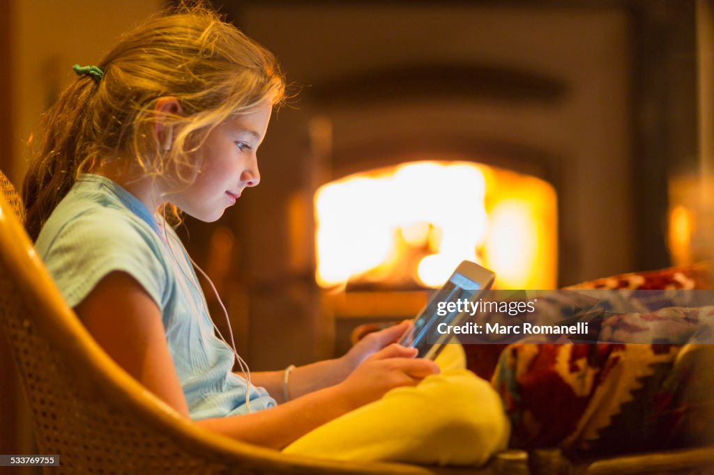 Caucasian girl using digital tablet in living room