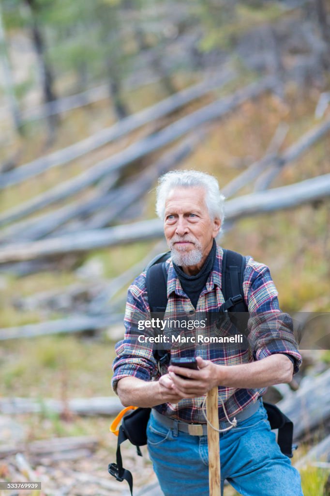 Caucasian hiker using cell phone in forest