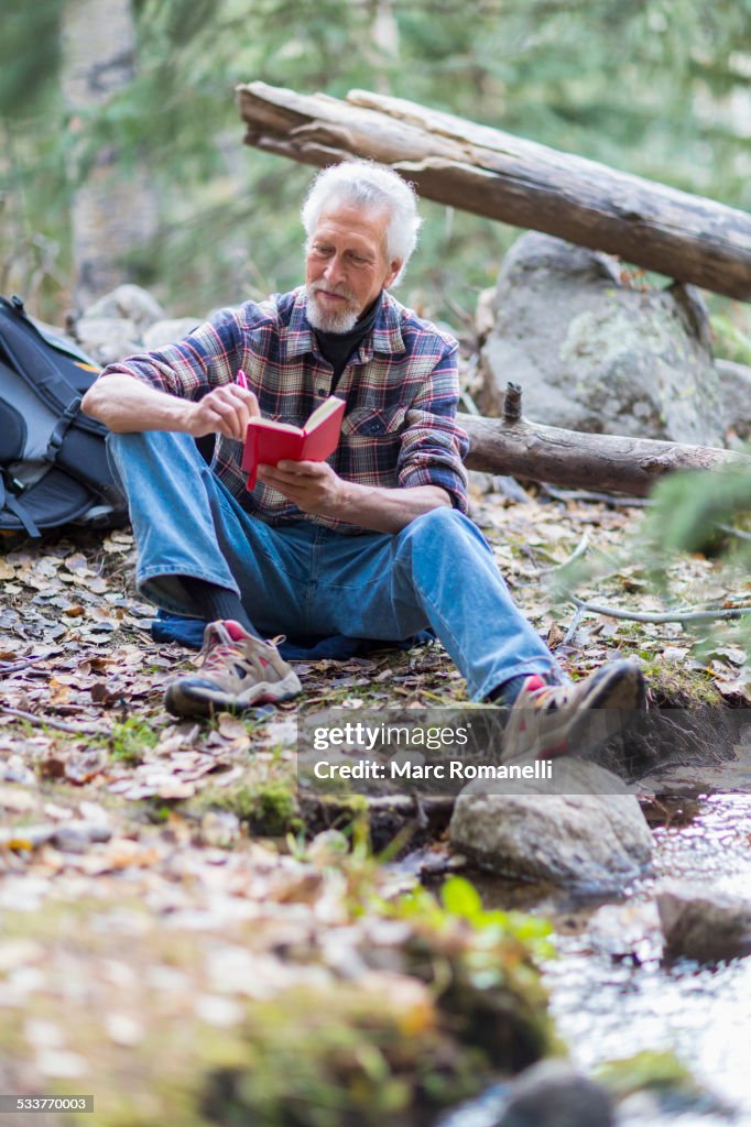 Caucasian hiker writing in forest