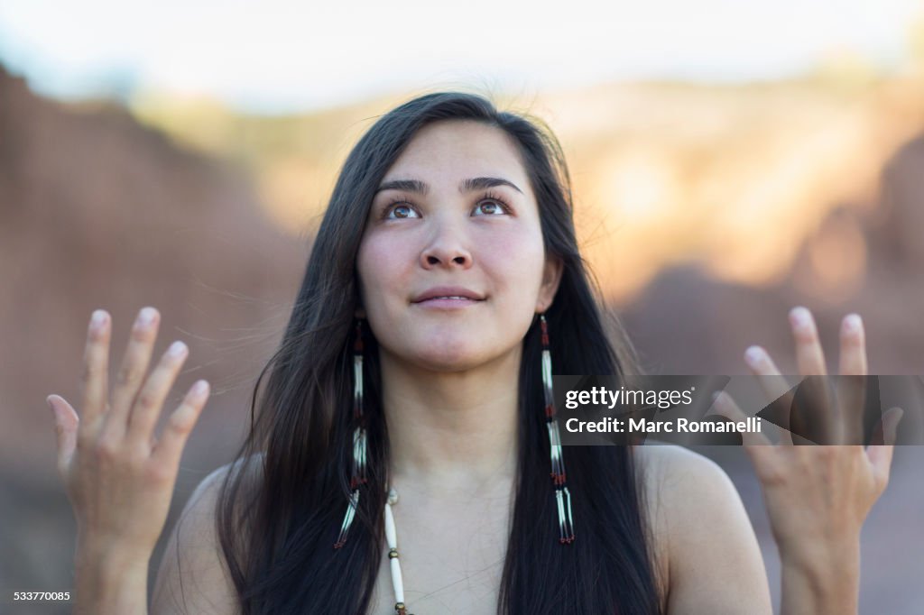 Mixed race woman meditating in desert