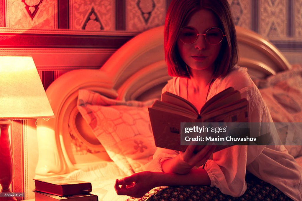 Caucasian woman reading on bed