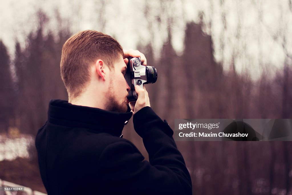 Caucasian man taking photograph outdoors