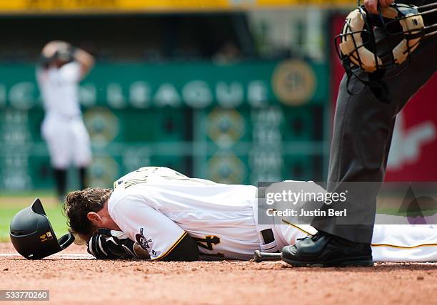 Ryan Vogelsong of the Pittsburgh Pirates lays on the ground after being hit in the head by a pitch thrown by Jordan Lyles of the Colorado Rockies in...