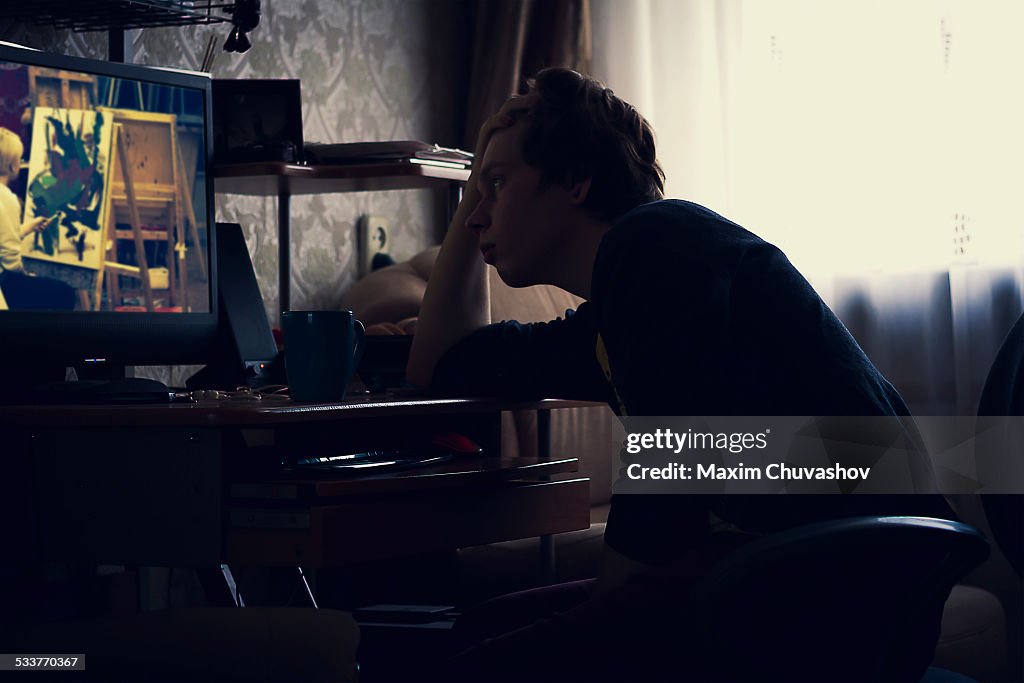 Caucasian man watching computer screen at desk