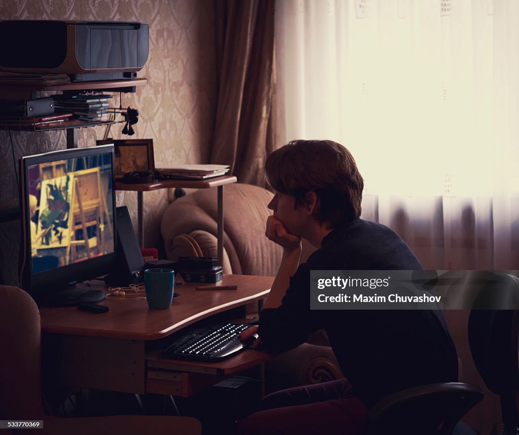 Caucasian man watching computer screen at desk