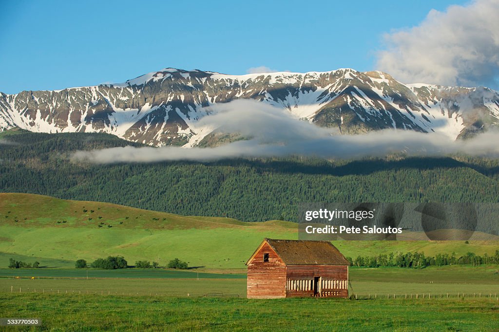 Mountains over barn in rural landscape