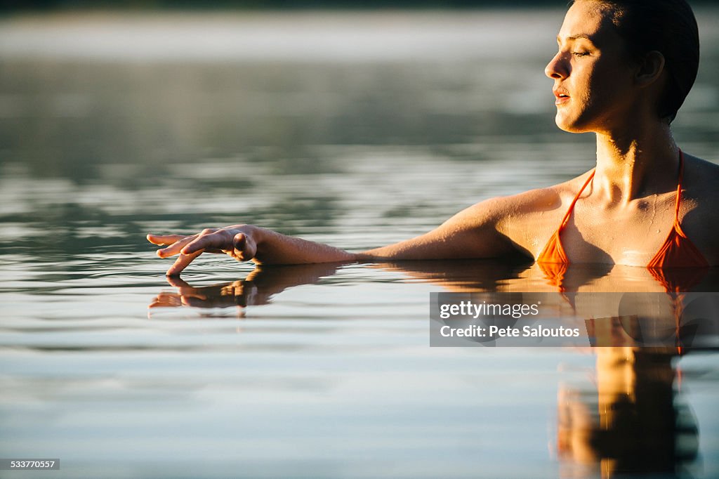 Caucasian woman swimming in still lake