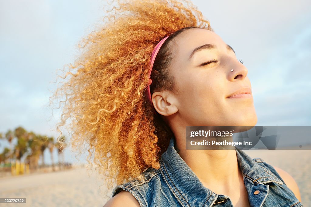 Hispanic woman smiling at beach