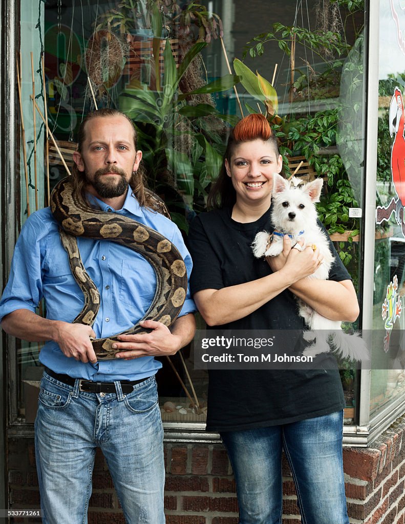 Caucasian couple holding pets outdoors