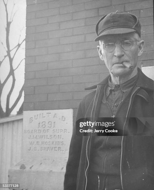 Older resident of Adair Co., standing at Courthouse cornerstone.