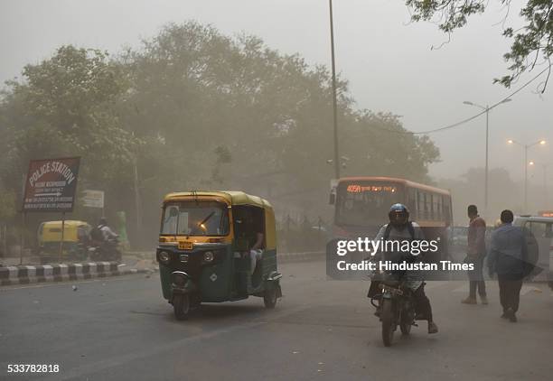 People caught in dust storm on May 23, 2016 in New Delhi, India. Sudden rains brought respite for people in capital after a hot and humid afternoon.