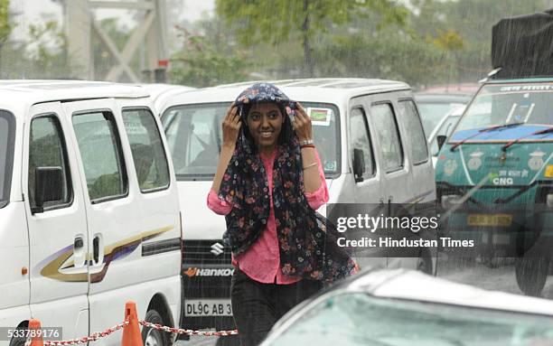 People caught in rain on May 23, 2016 in Noida, India. Light rains and dust storm brought much needed relief from searing heat in Delhi and...