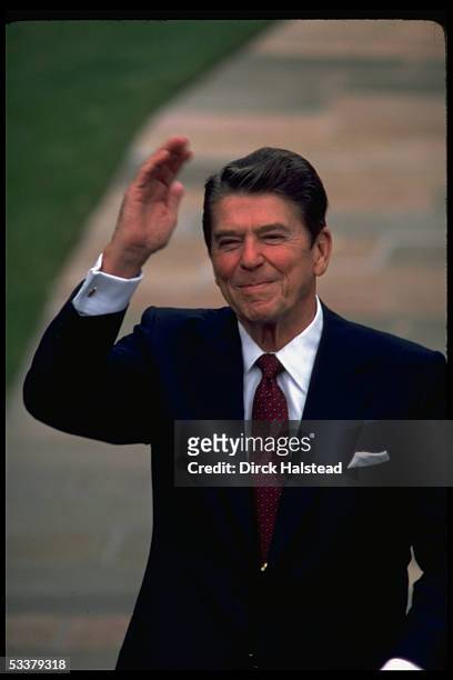 Portrait of President Ronald Reagan raising his hand in a wave upon arrival of Egyptian president Anwar Sadat at the White House.