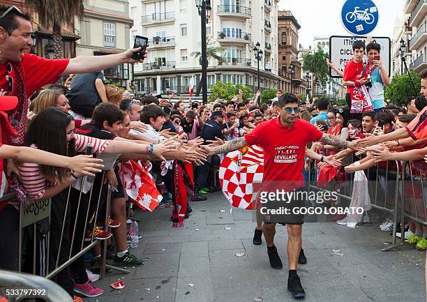 Sevilla's Argentinian midfielder Ever Banega is acclaimed by fans on a street of Sevilla on May 23, 2016 during the celebration of their third...