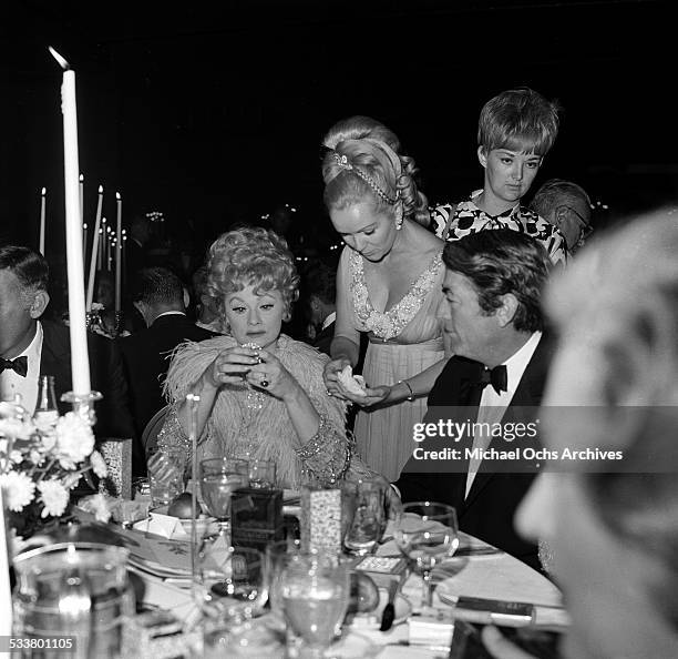 Actor Gregory Peck sits with actress Lucille Ball and actress Debbie Reynolds during an event in Los Angeles,CA.