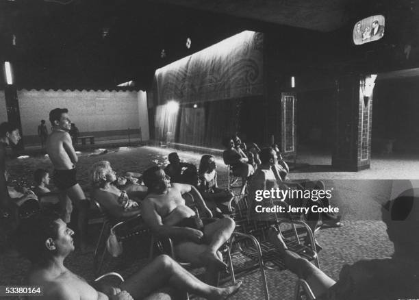 People watching TV at a hotel swimming pool.