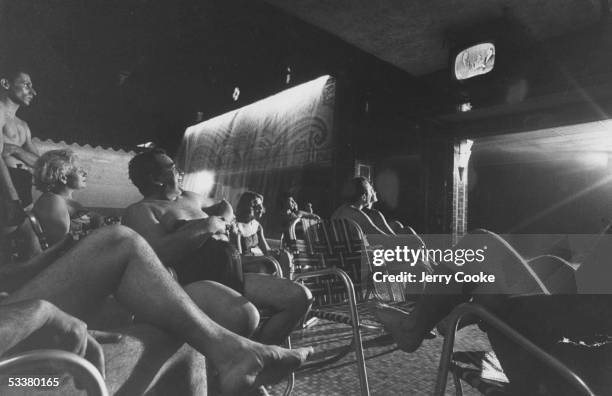 People watching TV at a hotel swimming pool.