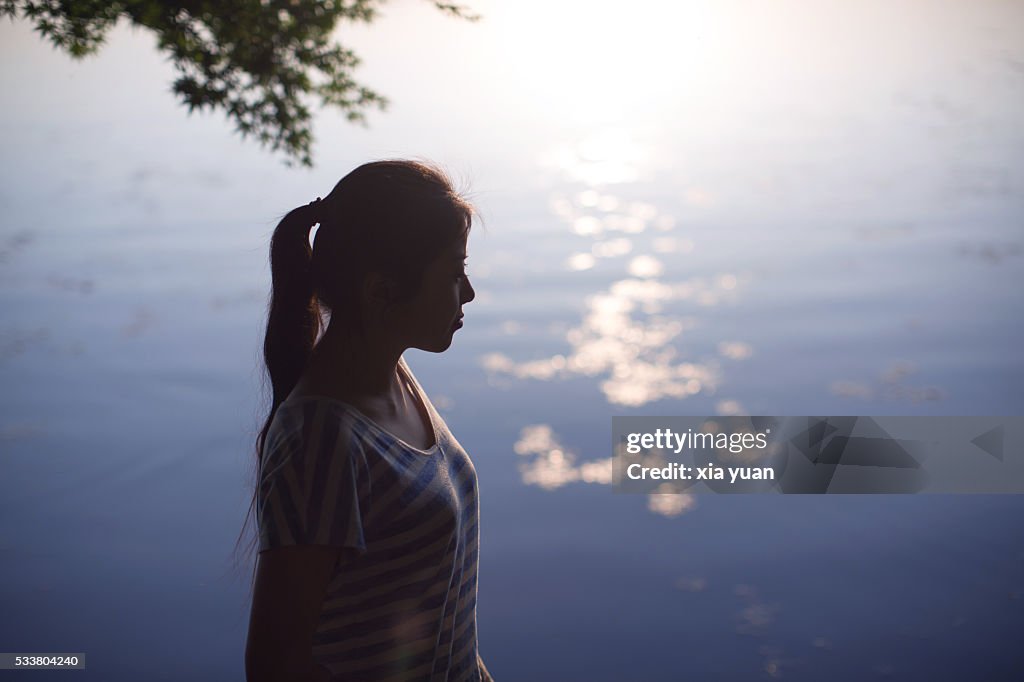 Young asian woman standing on lakeshore