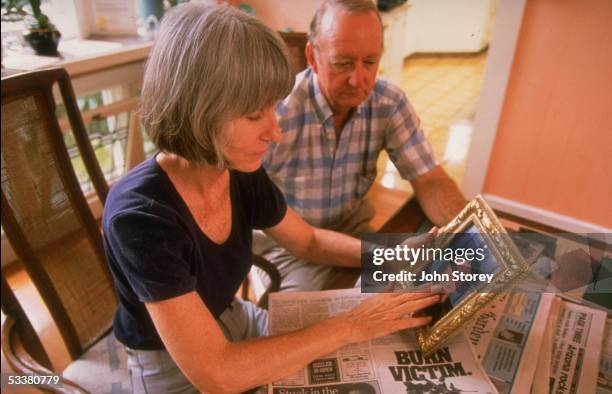 Rosemary & Nobert Smith looking at photo of their late son, University of Hawaii football placekicker Shannon, who died on 3/29/1997 while saving the...