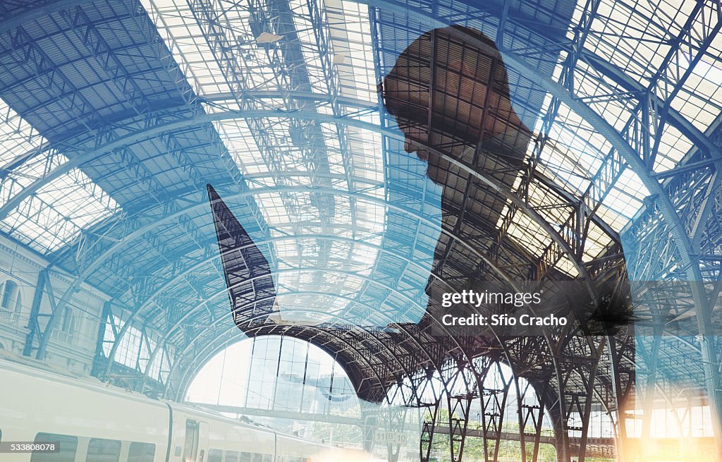 Man with laptop. Double exposure with train station.