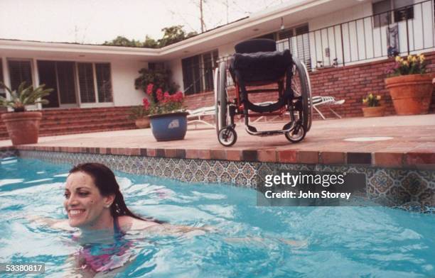 Wheel-chair bound deputy prosecutorJulie Alban taking a swim in her parents pool; nine years earlier she was paralyzed after being shot by boyfriend...