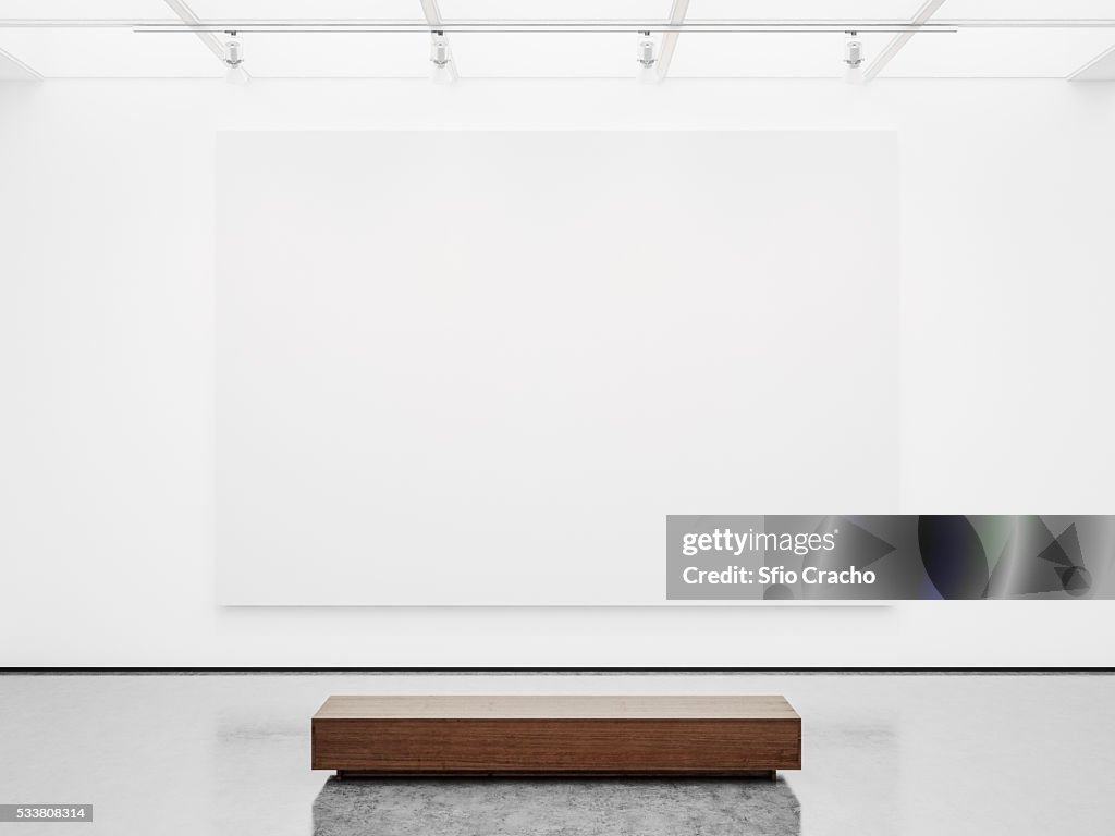 White interior of empty gallery with bench