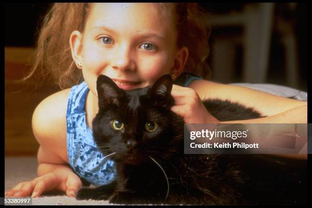 Stacey Rogers with her cat Midnight, who saved her from crib death when she was an infant, alerting her mother Bernita by meowing through a baby...