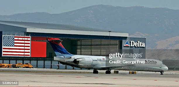 Delta Airlines jet passes the Delta hanger at the Salt Lake International Airport August 12, 2005 in Salt Lake City, Utah. The resent increase in...