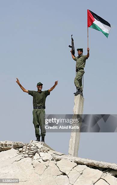 Palestinian security men wave their national flag near the Rafah refugee camp border with Egypt on August 13, 2005 in southern Gaza strip. As Israel...